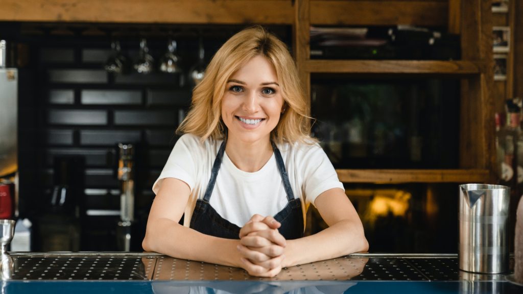 Waitress small business owner barista bartender standing at the bar restaurant counter